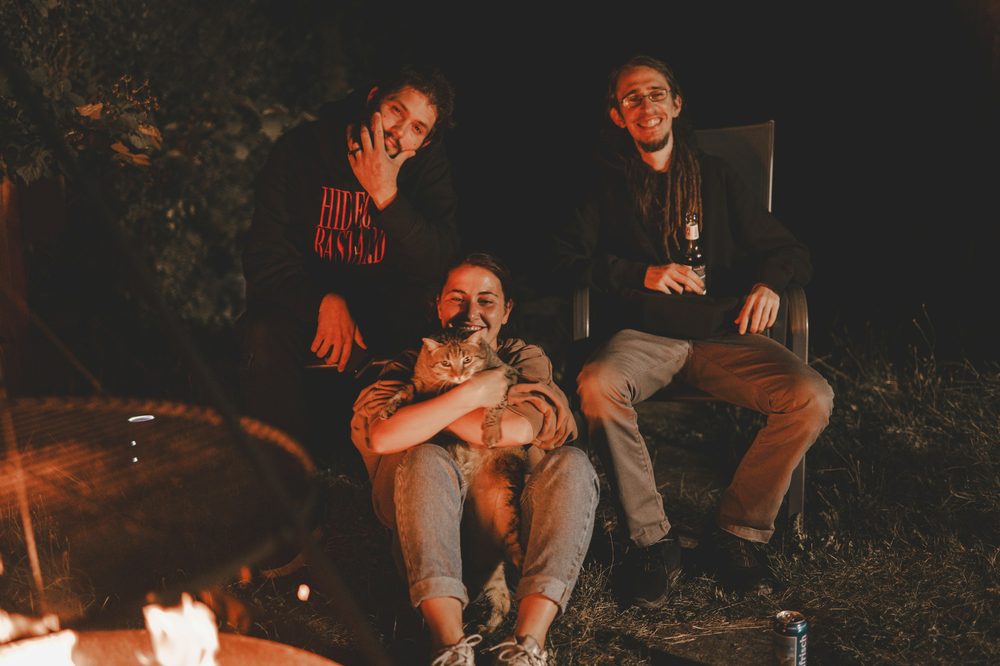 Friends relaxing outdoors under string lights at night