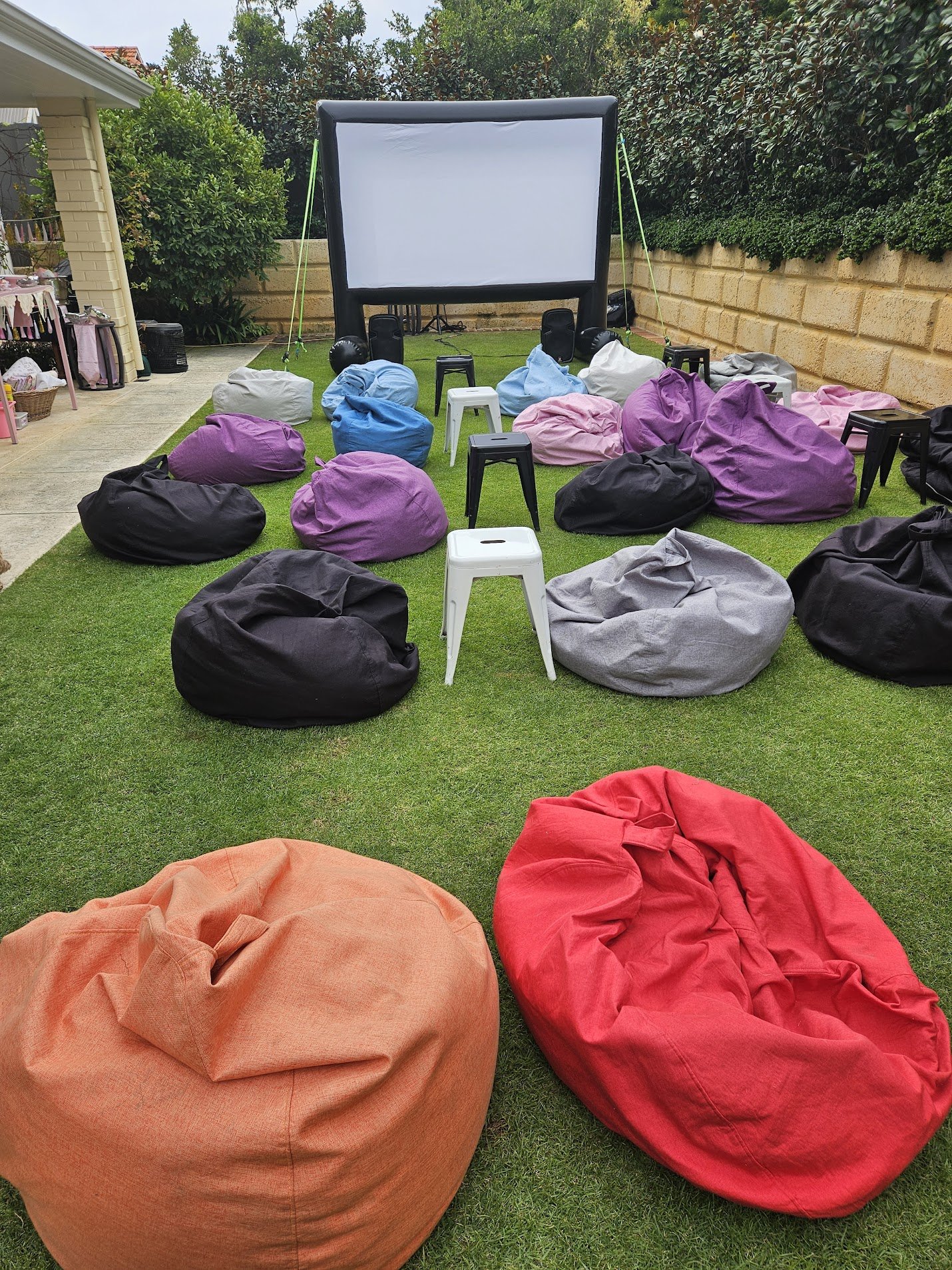 Outdoor cinema hire in Armadale: backyard movie night with a large inflatable screen and a colourful spread of bean bags, set up by Perth Pop-Up Movies