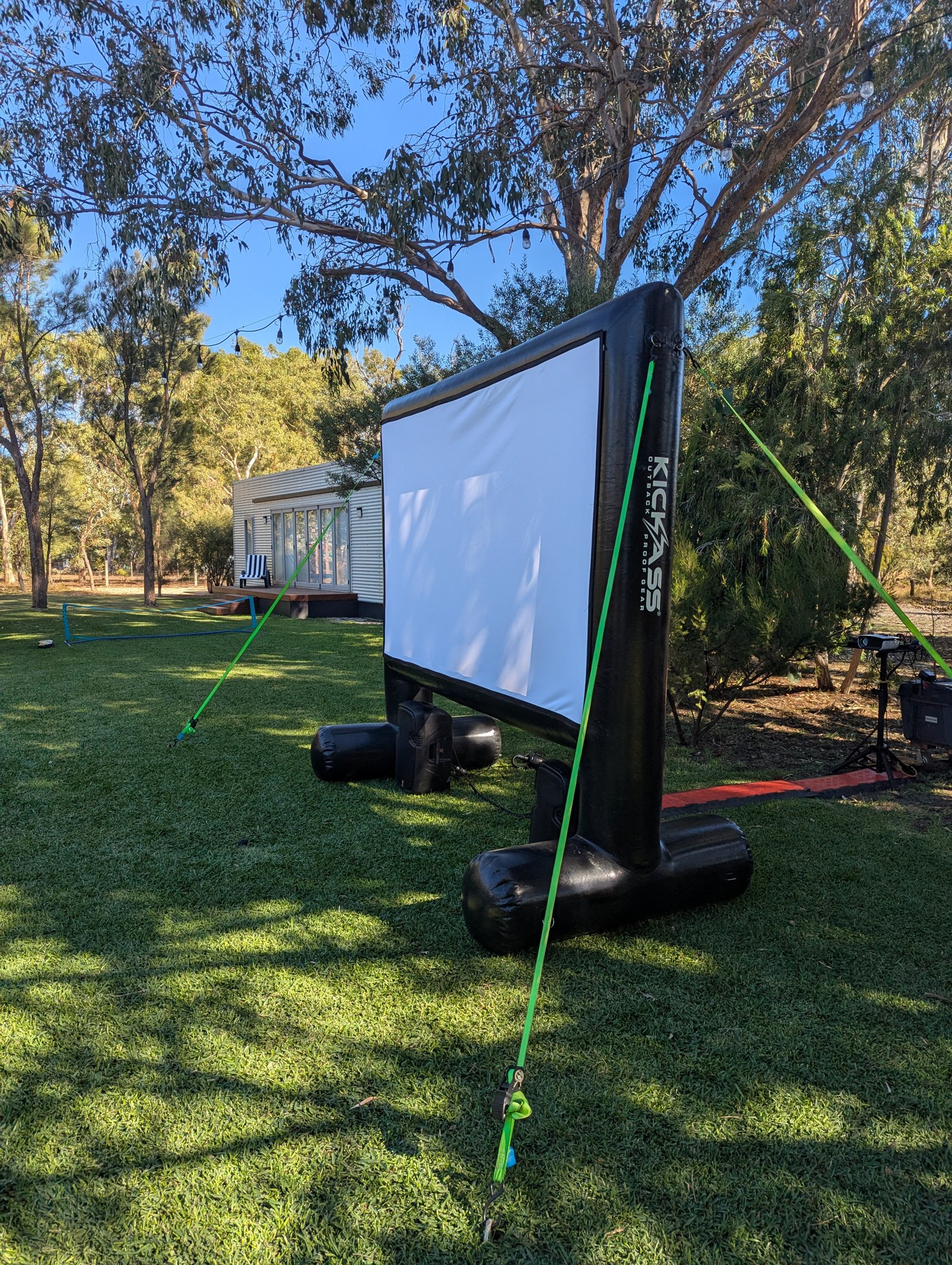 Outdoor cinema hire in Cockburn: inflatable movie screen set up on a lawn among gum trees for a backyard movie night by Perth Pop-Up Movies