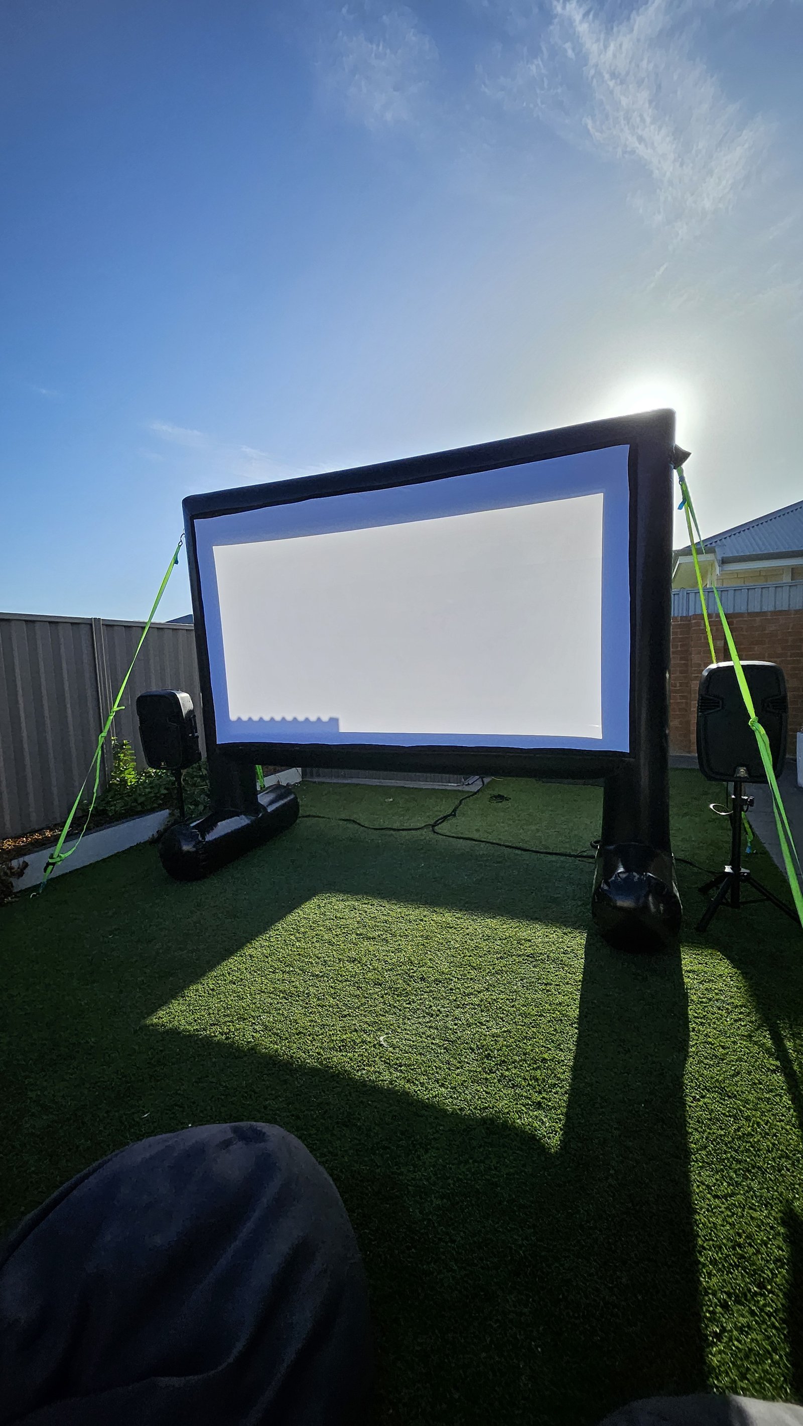 Outdoor cinema hire in San Remo: an outdoor movie screen and sound set up in a suburban backyard at dusk by Perth Pop-Up Movies