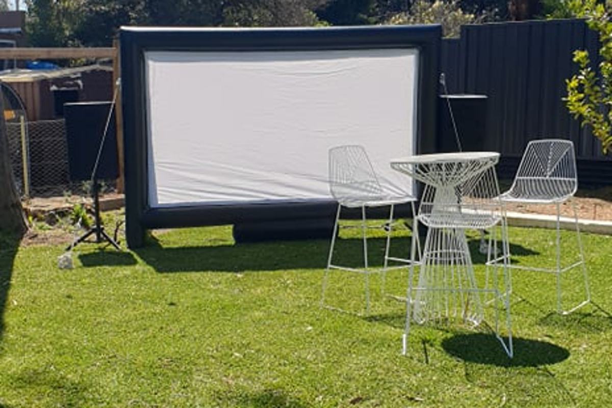 Styled outdoor cinema setup with seating on grass for a Perth community event