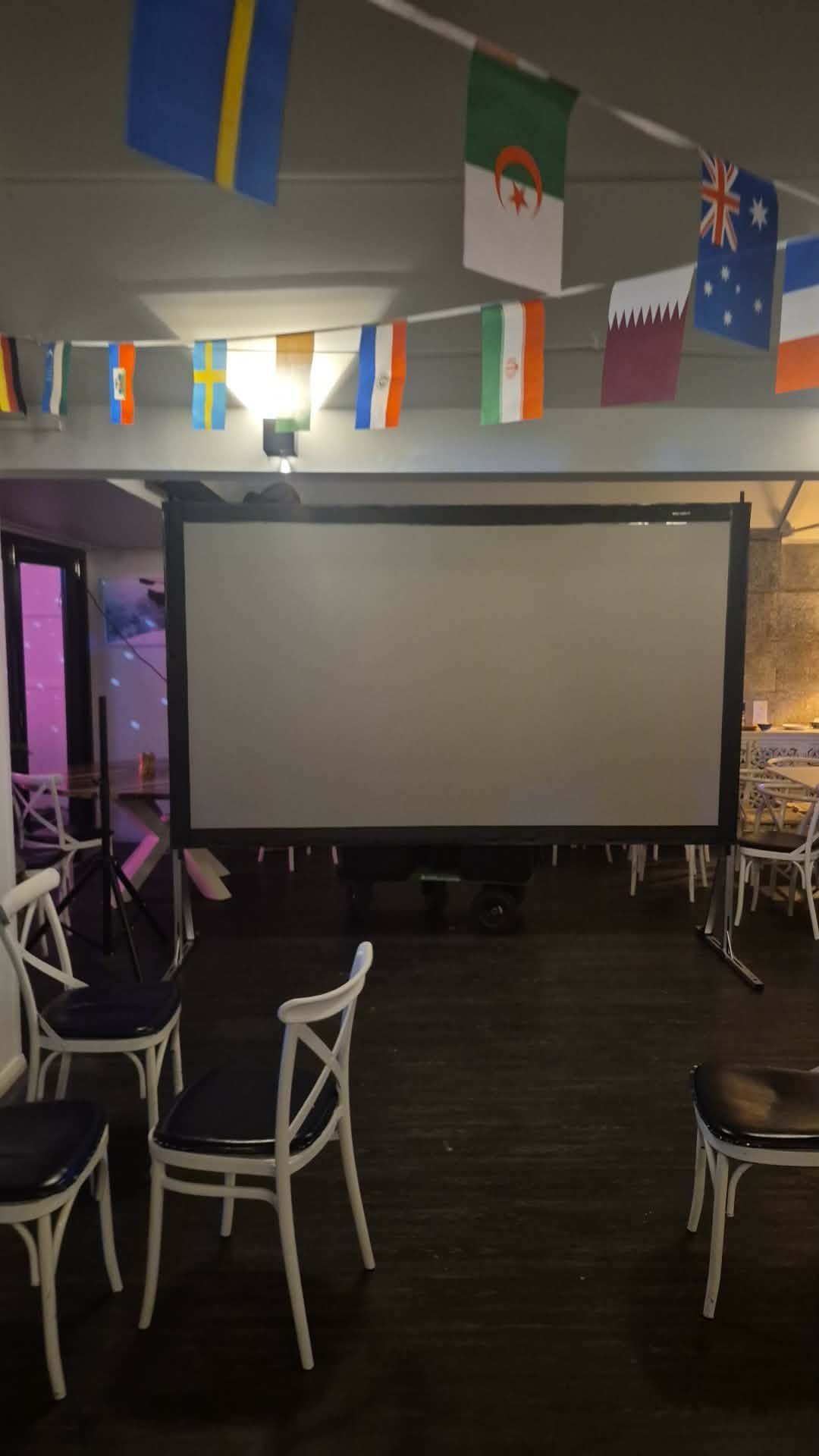 Perth Pop-Up Movies screen set up for an international football screening night, with team flags strung overhead