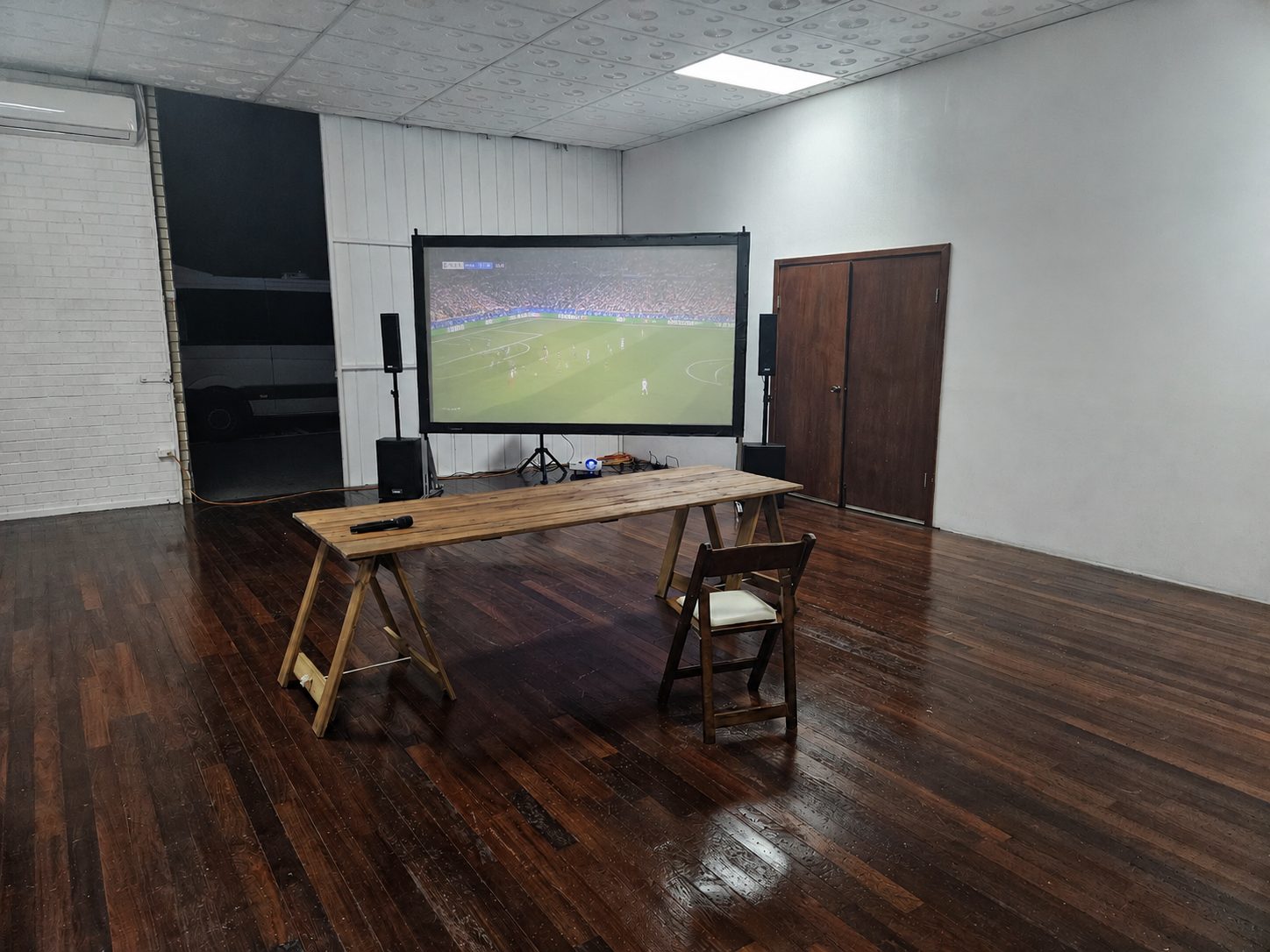 Live football match showing on Perth Pop-Up Movies' framed cinema screen with PA speakers either side