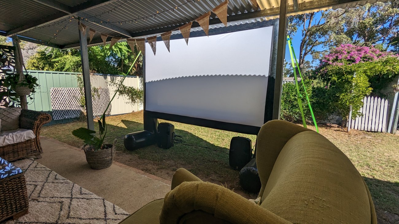 Backyard outdoor cinema screen with bunting and lounge seating in Perth