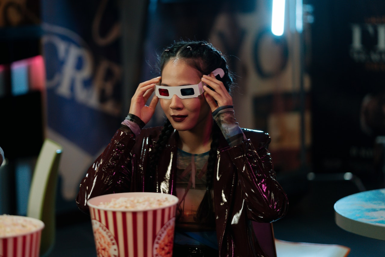 woman wearing 3d glasses with popcorn in front of her